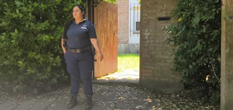 Una policía custodia el ingreso a la vivienda.